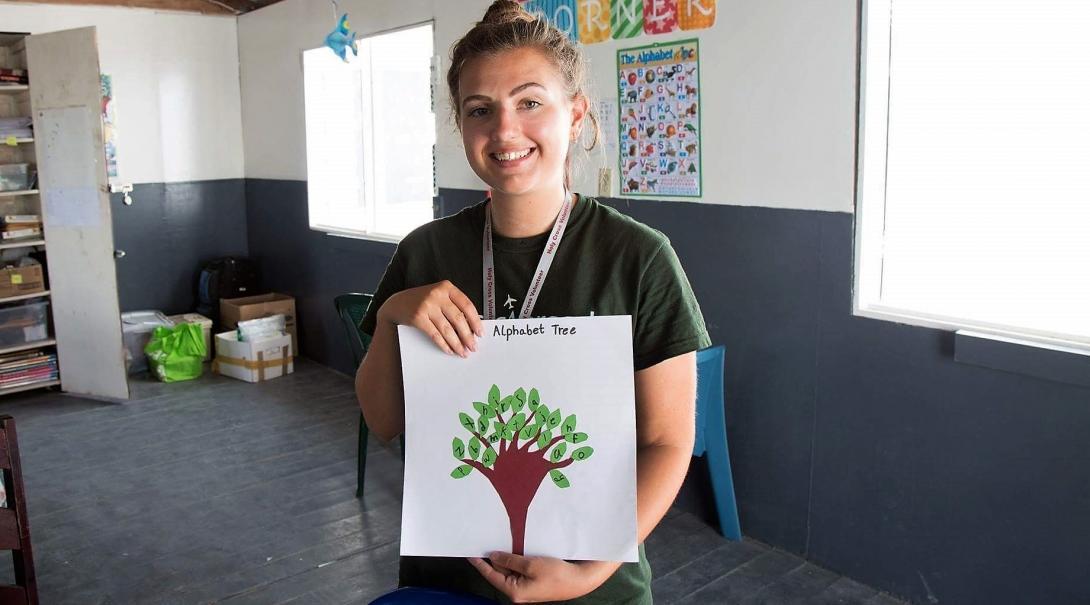 A volunteer teaching in Belize holds up an alphabet tree created by one of her students on the literacy project Projects Abroad volunteer holds up an alphabet tree created by one of her students at her Teaching placement in Belize